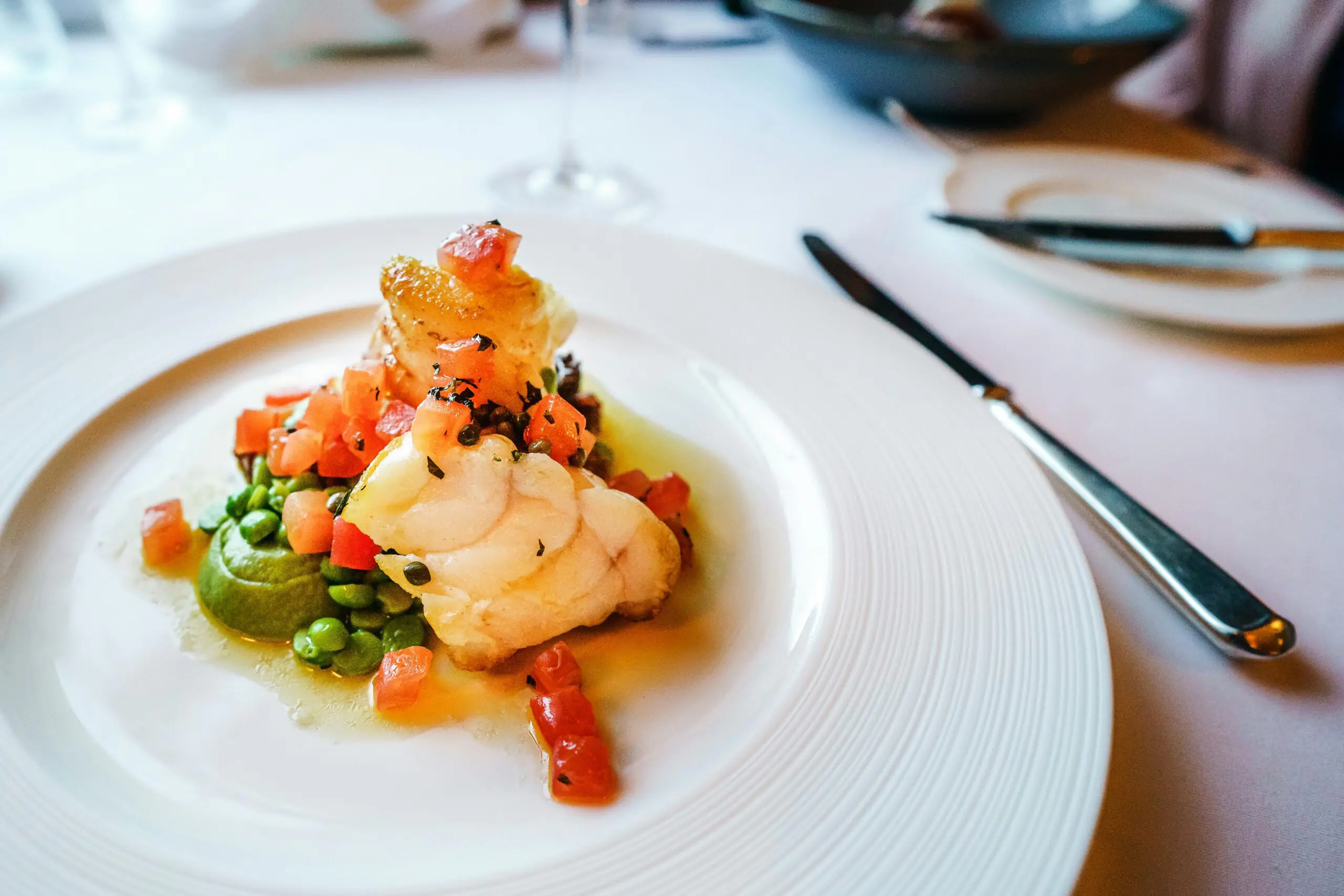 Gourmet fish dish with peas and tomato garnish